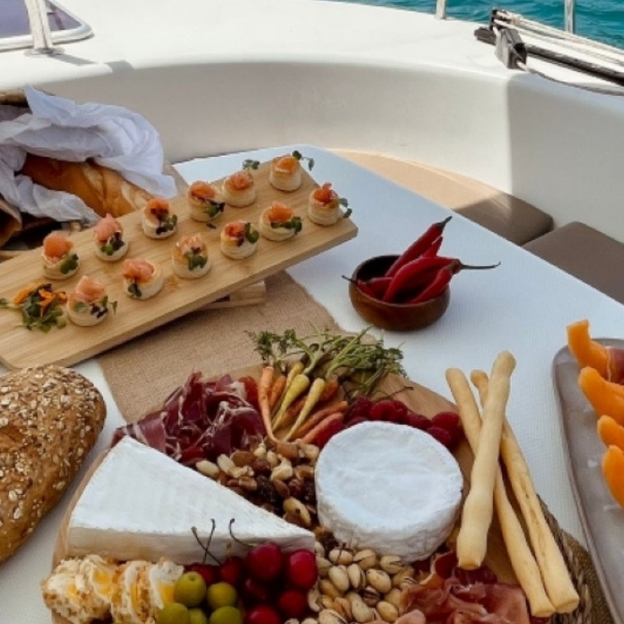 Andalusian sharing platter on board: cheeses, cured meats, olives, breadsticks and canapés